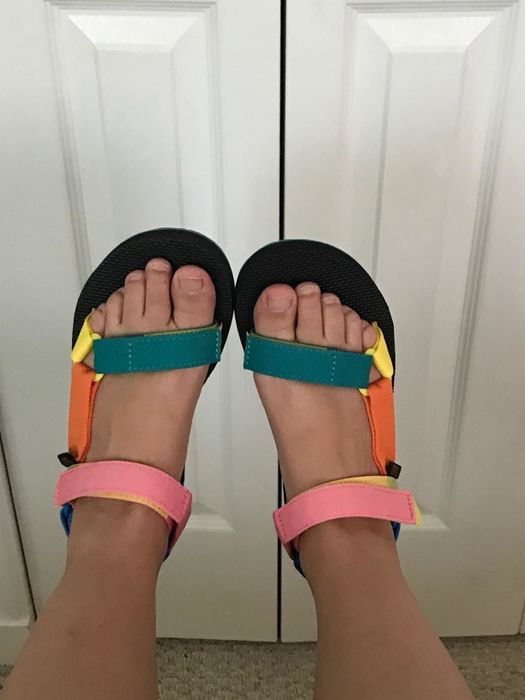 A reviewer wearing the sandals in the 90s multi-colorway