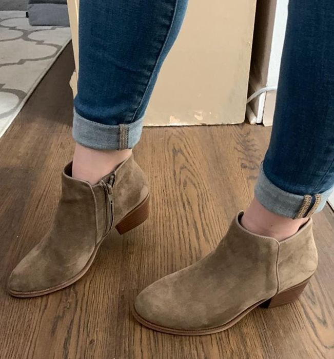 A reviewer showcasing ankle boots styled with jeans