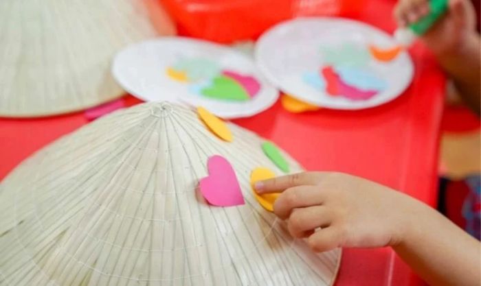 Trang trí nón lá bằng cách dán giấy màu hình trái tim
