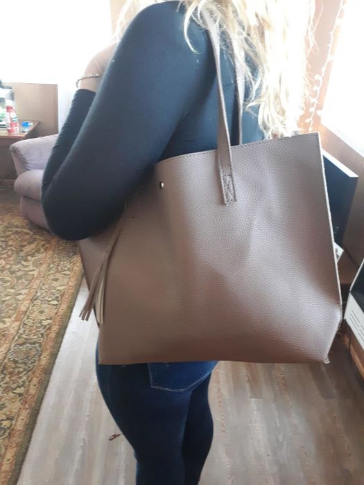 Reviewer carrying a tan tote bag