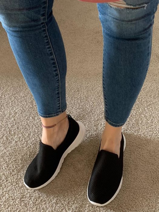 Reviewer wearing black and white Skechers GoWalk Joy sneakers