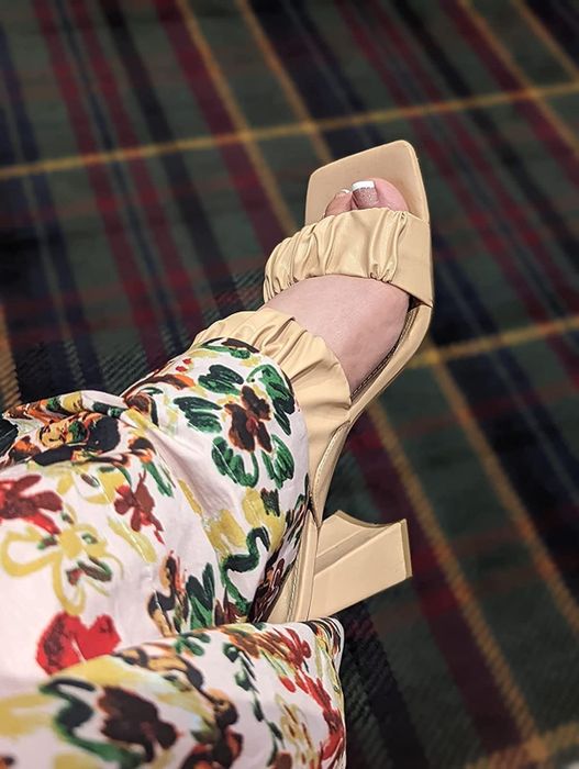 A reviewer wearing the beige ruffle square-toe strap sandals