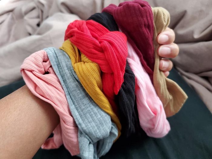 The same reviewer holding all the headbands from the Color-2 pack.