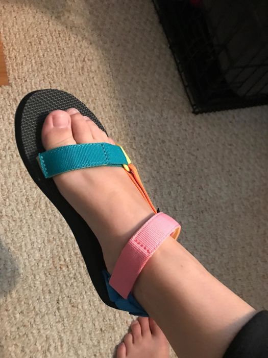 A reviewer wearing the sandals in the 90s multi-colorway
