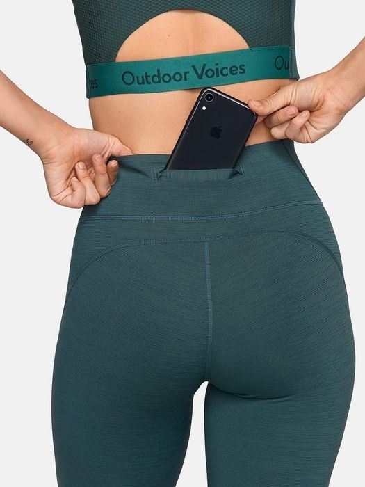 A close-up view of the leggings' back pocket holding a phone.