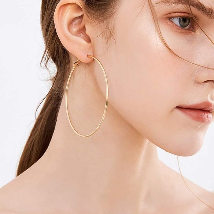 Model wearing a gold hoop earring on the right ear