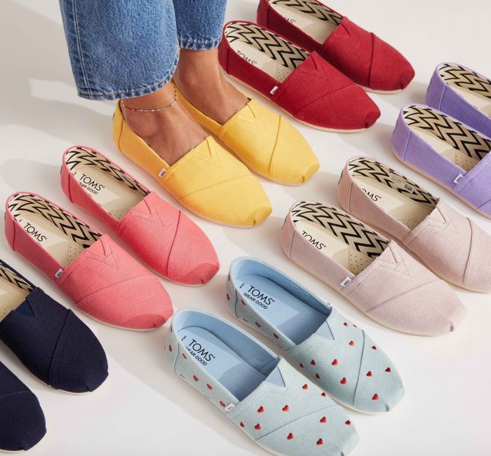 An assortment of TOMS shoes in different patterns and colors arranged in a semi-circle