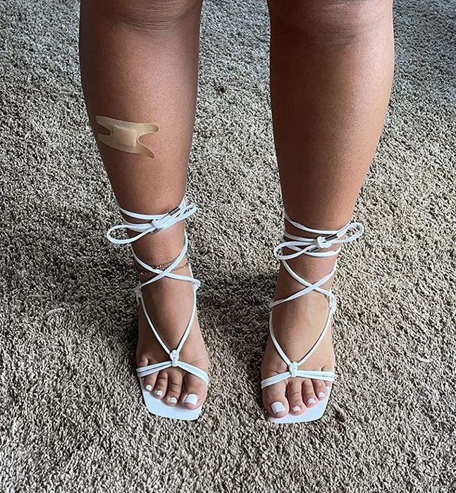 A reviewer wearing the white sandals
