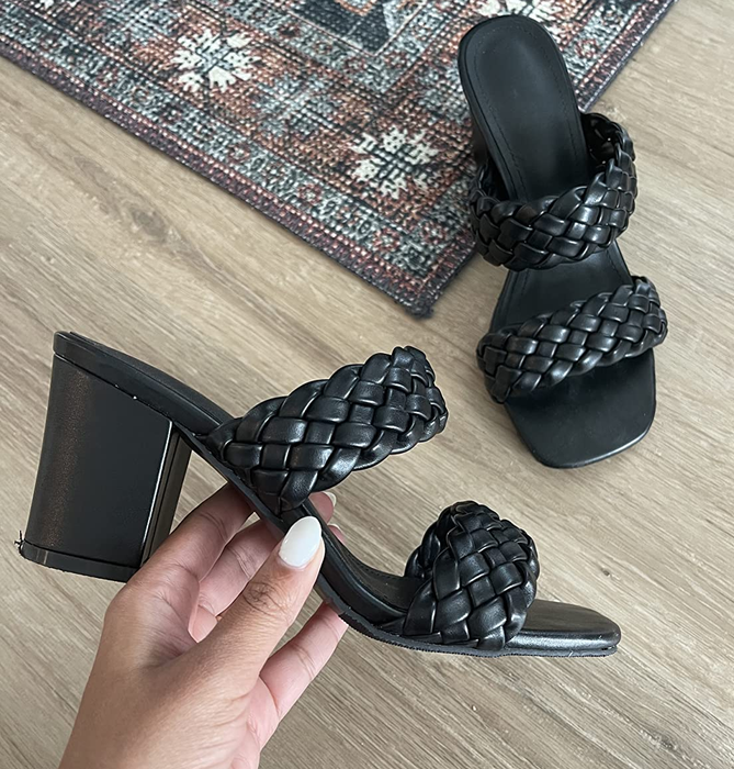 A close-up of a reviewer holding the black sandal