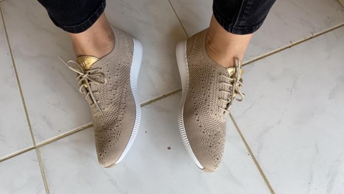 reviewer posing in stylish tan and gold sneakers perfect for a laid-back look