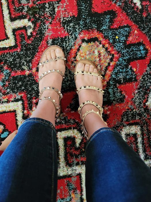 A reviewer wearing gold-tone studded sandals
