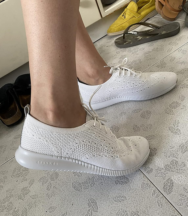 A side angle of the white Cole Haan sneakers, highlighting their modern and stylish design.