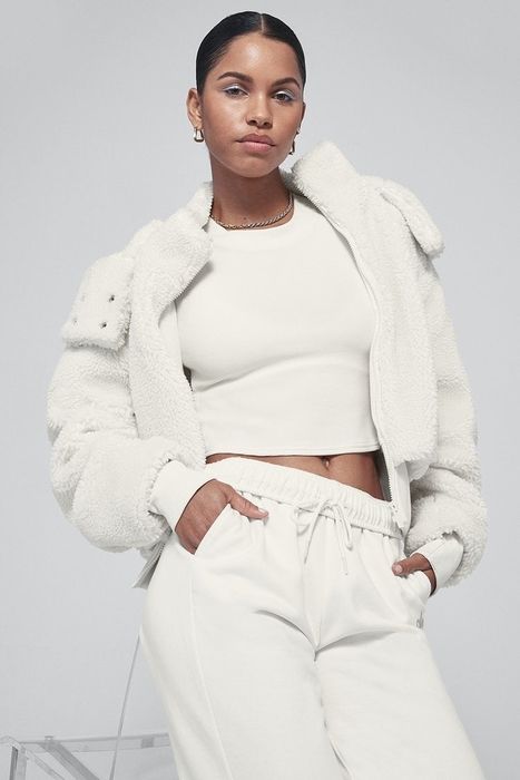 Model wearing a white sherpa hoodie by Alo Yoga