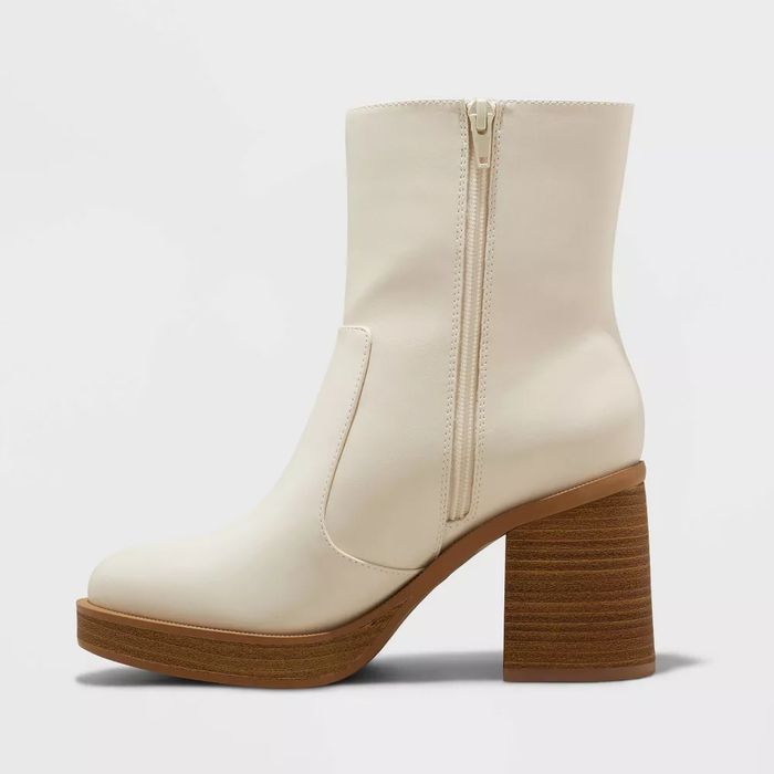 White ankle boot featuring a zipper and a brown block heel