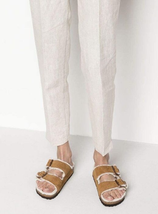 A model wearing the sandals in mink.