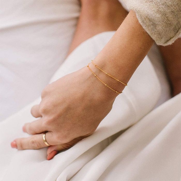 Model showcasing a layered gold bracelet