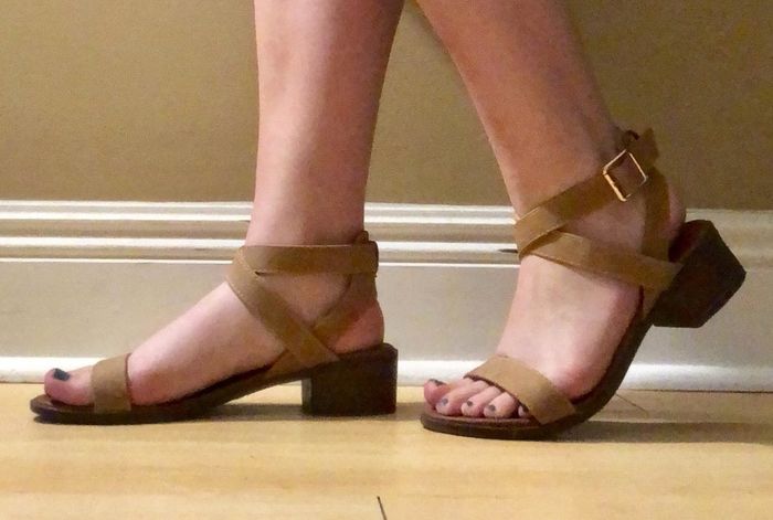 A photo of a reviewer wearing the brown block heel sandals
