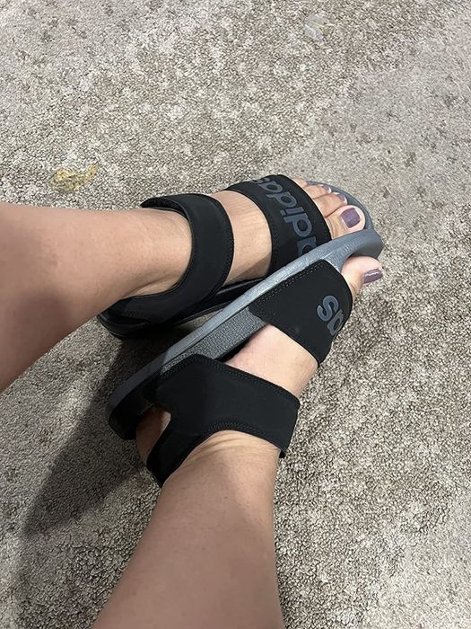 A reviewer wearing the black and grey sandals