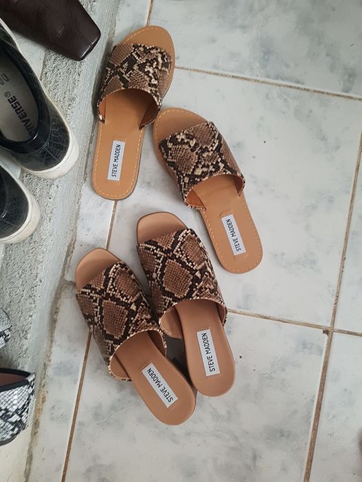 A reviewer wearing the snakeskin print sandals