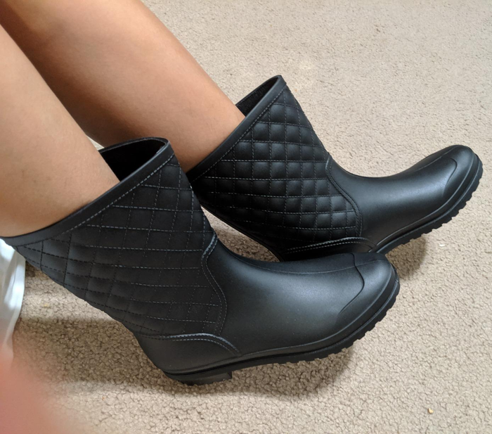 close-up of the black rain boots on a reviewer's feet