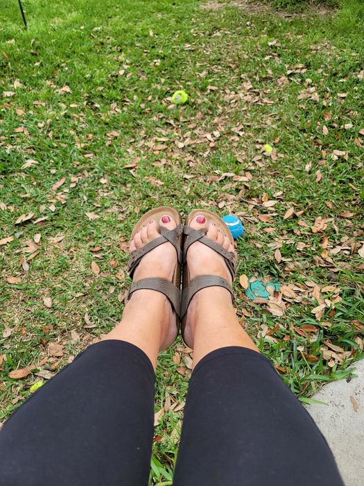 reviewer wearing the grey pebbled sandals