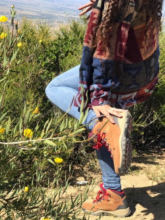 a reviewer wearing the red and brown boots outdoors