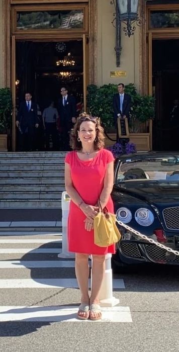 reviewer standing in a crosswalk, wearing beige wedge sandals with a pink dress