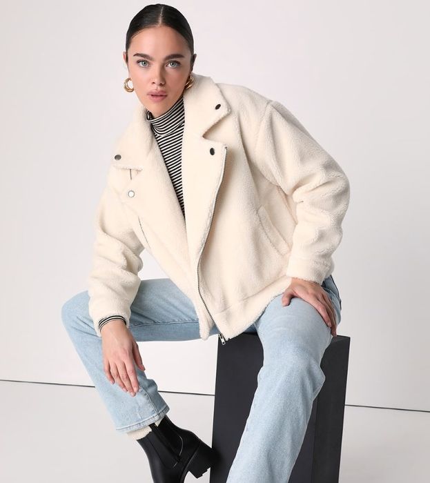 A model is showcasing the white moto shearling jacket.