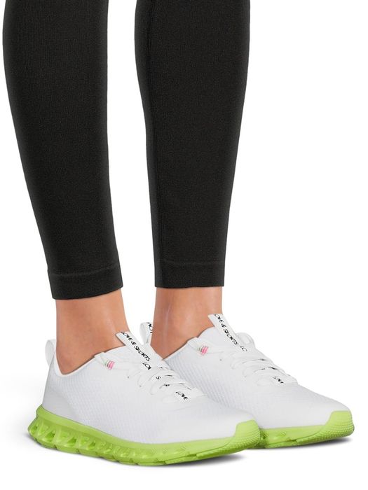 a model wearing the white and neon green sneakers