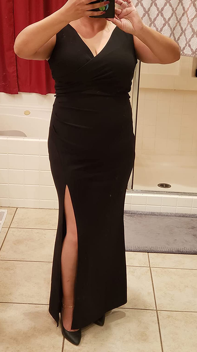A reviewer taking a mirror selfie in a black dress