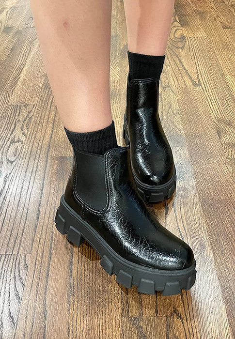 reviewer sporting the chunky black boots in a glossy crinkle finish