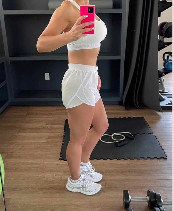 another reviewer showcasing the same white running sneakers while at the gym