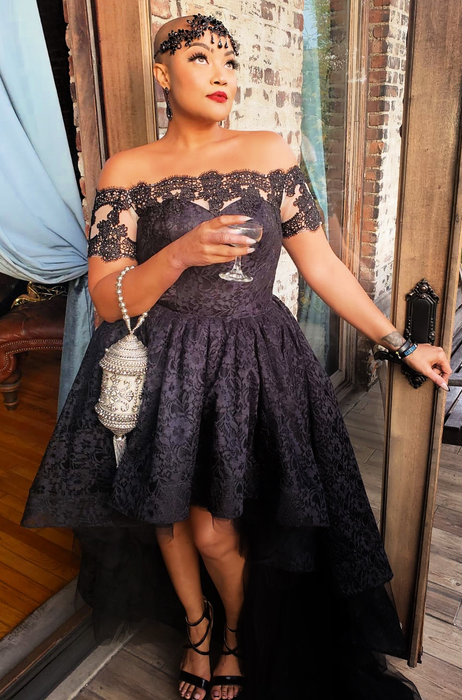 A reviewer in the black dress paired with a silver purse