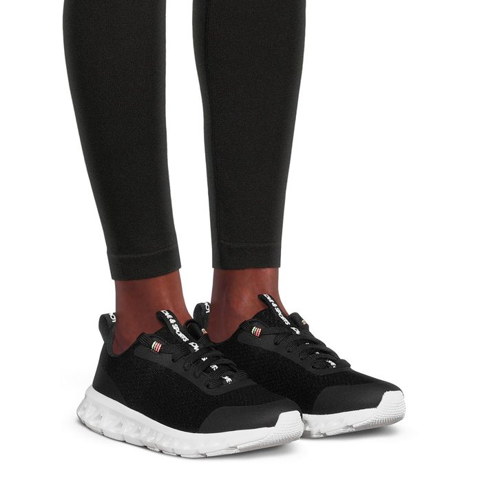 a model wearing the black and white sneakers
