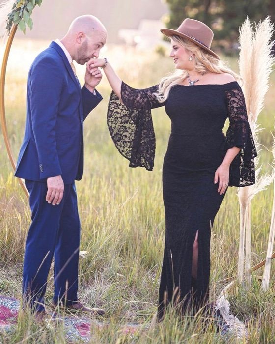 A reviewer in a long black dress paired with a cowboy hat