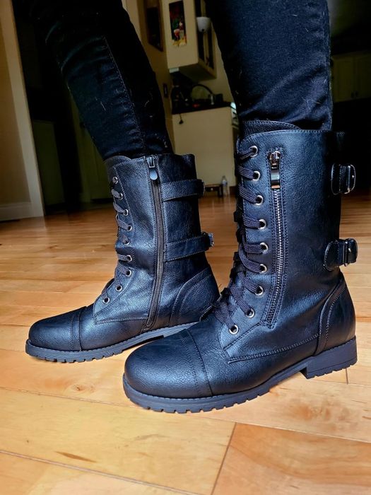 close-up of a reviewer showcasing the black combat boots