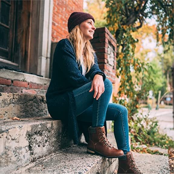The model is showcasing a stylish pair of brown boots.