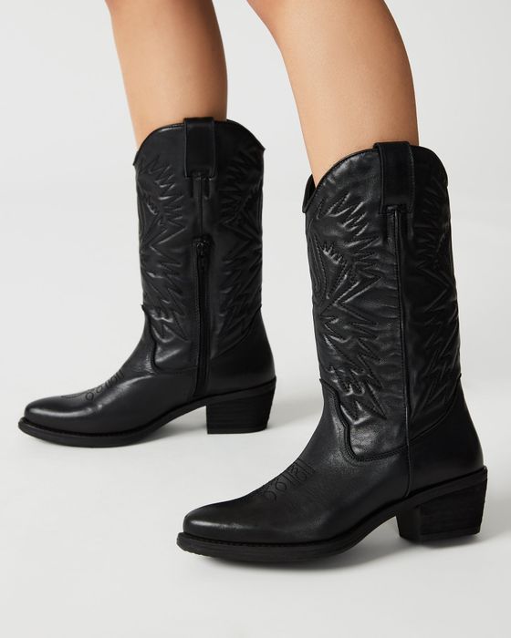 close-up of a model showcasing the black cowboy boots