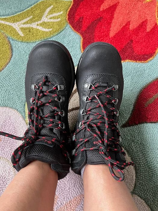 detailed shot of a reviewer showcasing the black and red hiking boots