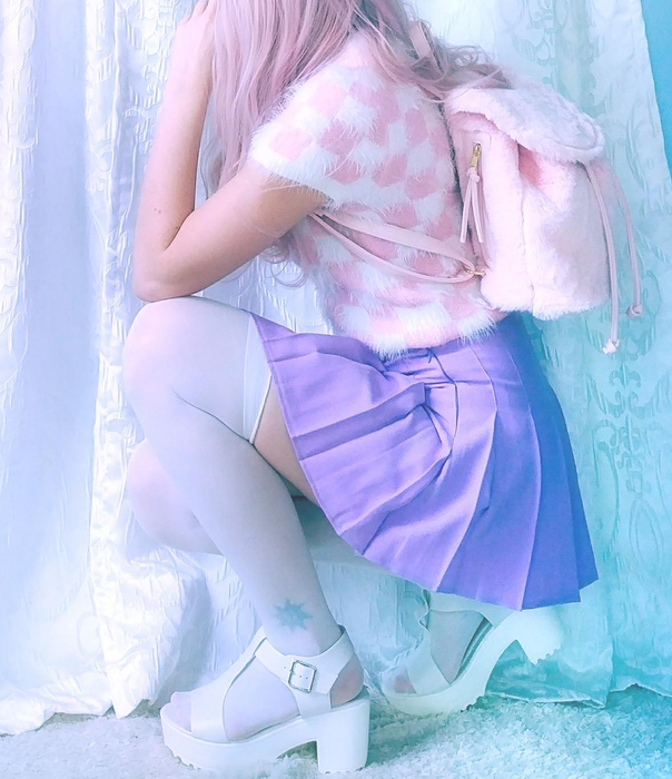 A reviewer is shown wearing white sandals with tights.
