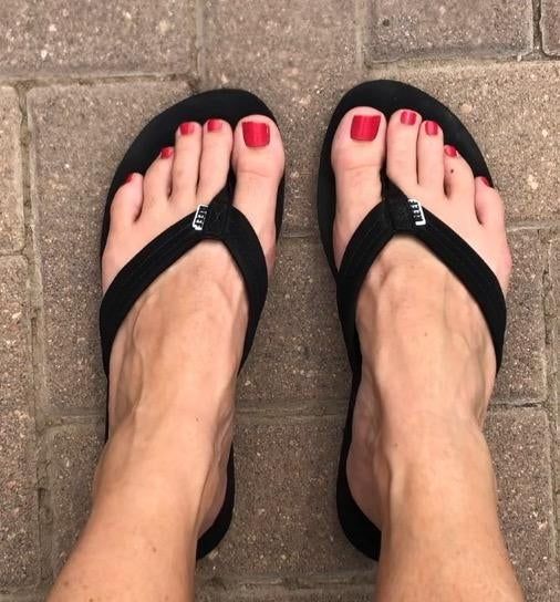 A reviewer wearing black flip-flops with thick straps