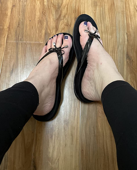 A reviewer wearing the black sandals