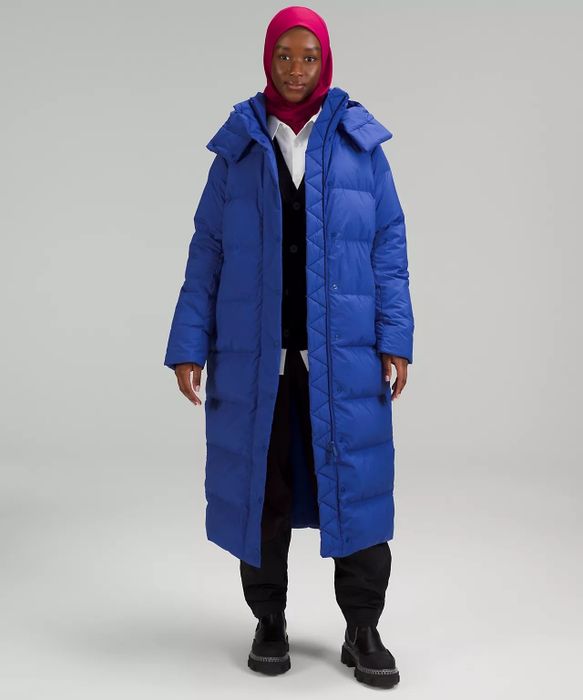A model showcasing a blue puffer coat layered over a black and white outfit