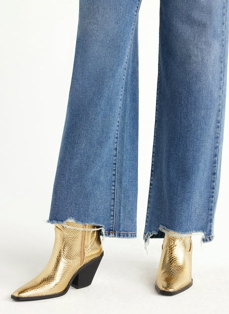 A model styling gold Western-style booties with wide-leg jeans
