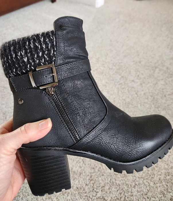 a reviewer holding up a black chunky-heeled boot