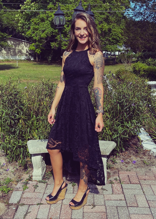 A reviewer in the black hi-low dress