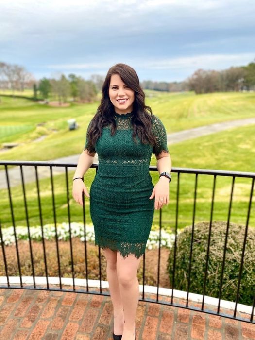 A reviewer wearing the dress in a green shade