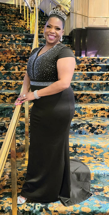A reviewer in a long black dress posing on steps