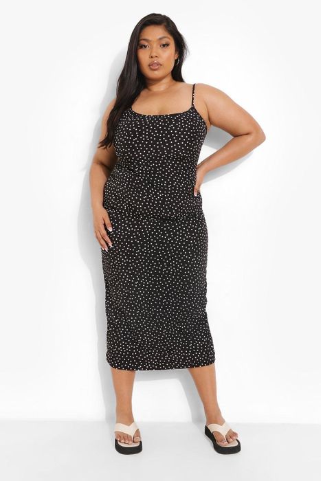 Model wearing a chic black polka dot dress