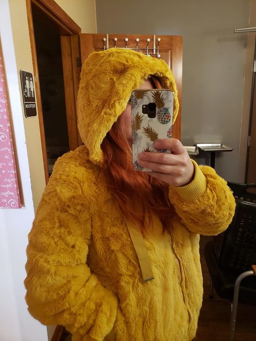 A reviewer showcasing a yellow jacket